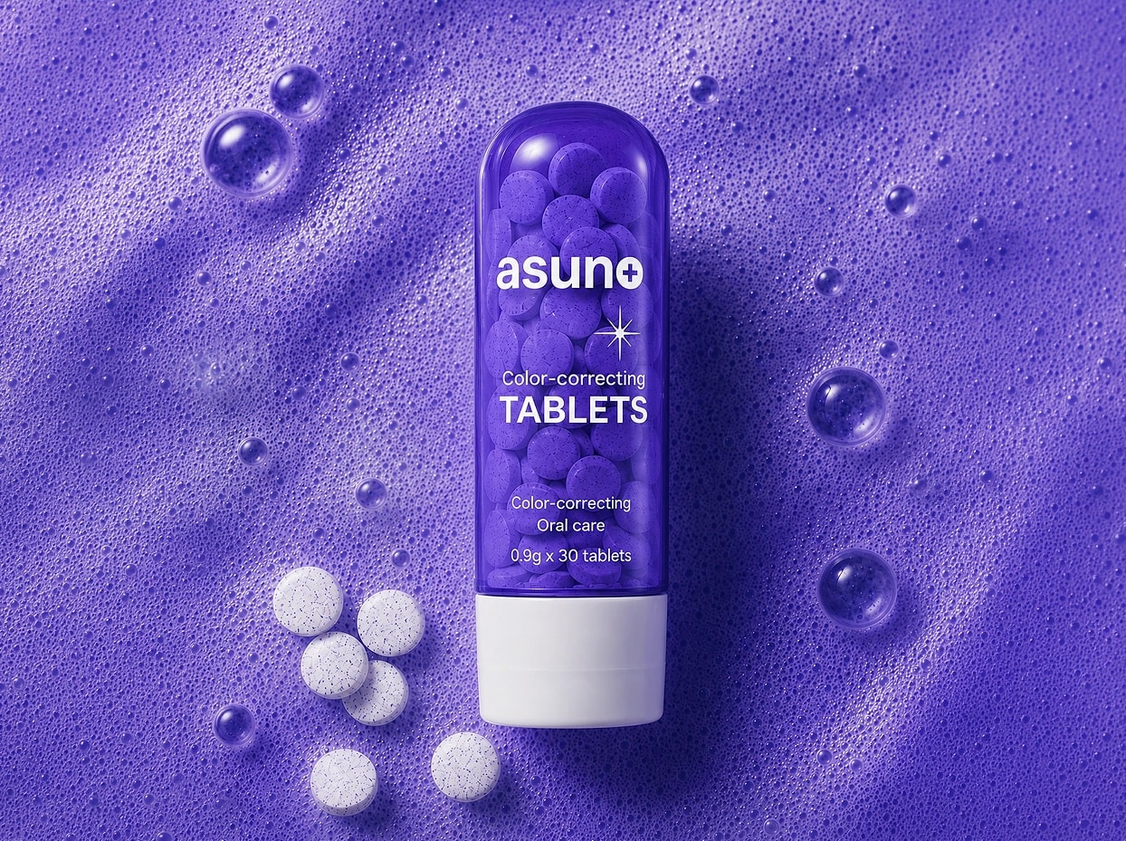 Blue capsule labeled 'asuno Color-correcting Tablets' with white tablets nearby on a textured blue surface